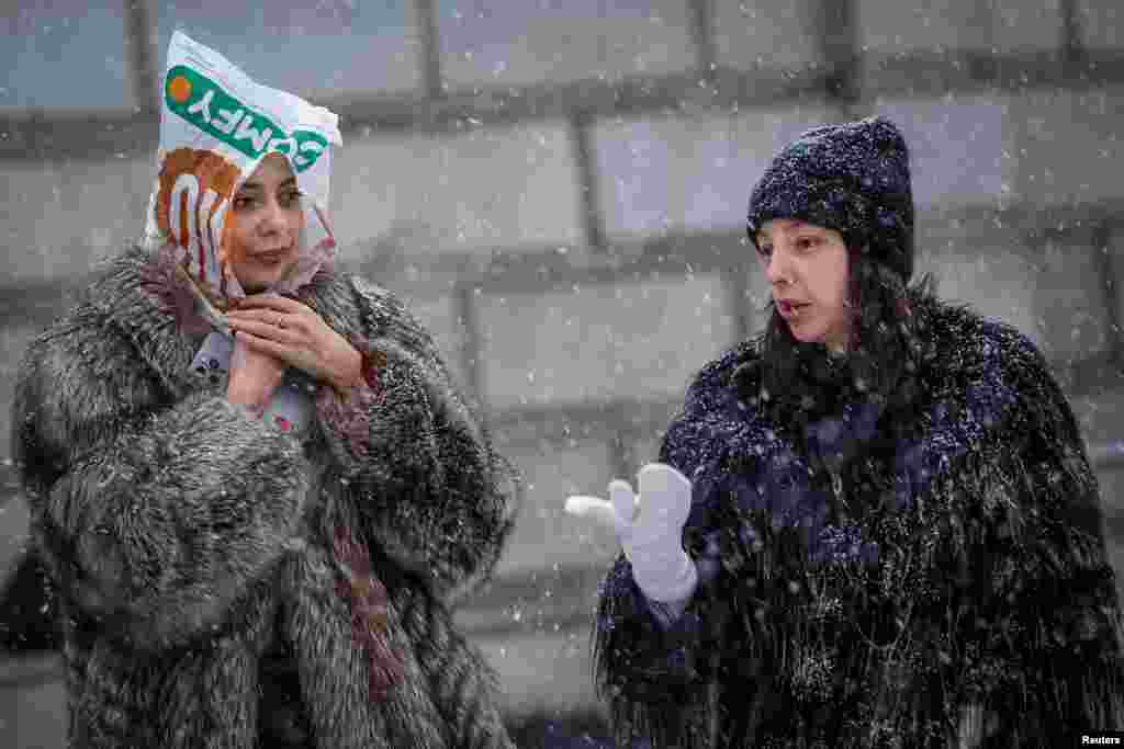 Women walk on a snow-covered street during a snowfall, in Kyiv, Ukraine.