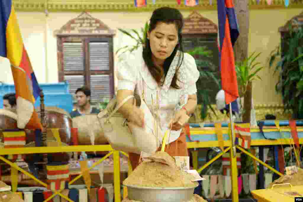 ពុទ្ធបរិស័ទពូនភ្នំខ្សាច់ដើម្បីរំដោះកម្មពារនៅក្នុងវត្តមួយកណ្តាលរាជធានីភ្នំពេញកាលពីព្រឹកថ្ងៃសៅរ៍ ទី១៦ ខែ កញ្ញា ឆ្នាំ២០១៧។(ទុំ ម្លិះ/VOA)