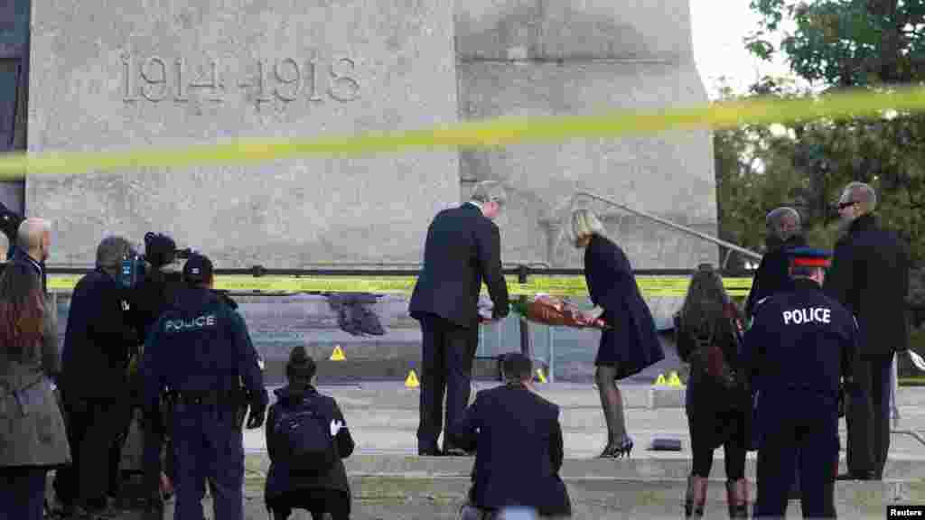 Canada's Prime Minister Stephen Harper and his wife, Laureen Harper, lay flowers at the National War Memorial in downtown Ottawa October 23, 2014.