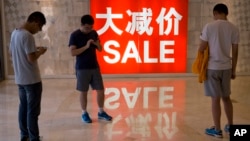 資料照片: 2016年7月10日中國北京購物區促銷廣告與購物者