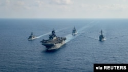 Kapal fregat berpeluru kendali Angkatan Laut Australia HMAS Parramatta (FFH 154) (kiri) berlayar dengan kapal serbu Amfibi Angkatan Laut AS USS America. (Foto: Reuters)