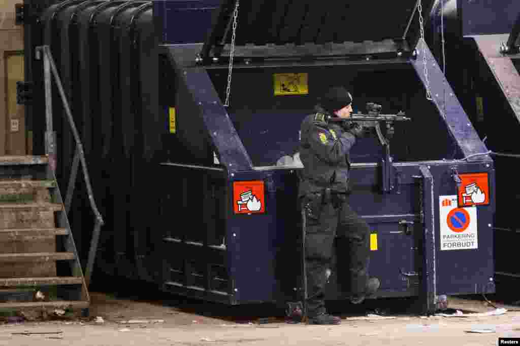 Armed police works in a cordoned off area in a street near Norrebro Station following shootings in Copenhagen, Denmark, Feb. 15, 2015.