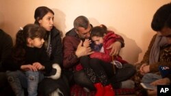 In this Feb. 12, 2020 photo, Malak Saad Dakhel, an 11 year-old Yazidi, is overwhelmed by journalists and well-wishers as her family tries to comfort her after her escape from Syria, in Sharia, Iraq.