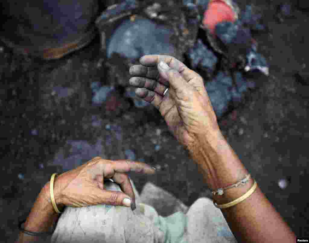 Hands of a Buddhist woman are seen as she tries to salvage her belongings from her burned home after Muslims attacked it in Cox's Bazar, Bangladesh, October 1, 2012.