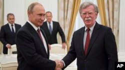 Russian President Vladimir Putin, left, shakes hands with U.S. National security adviser John Bolton during their meeting in the Kremlin in Moscow, Russia, June 27, 2018. 