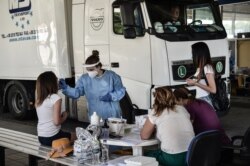 Seorang petugas kesehatan mengumpulkan sampel swab untuk menguji Covid-19, di Promachonas, perbatasan Yunani-Bulgaria, 10 Juli 2020. (Foto: dok).