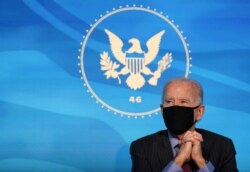 FILE - U.S. President-elect Joe Biden listens to remarks from a nominee at his transition headquarters in Wilmington, Delaware, Jan. 8, 2021.
