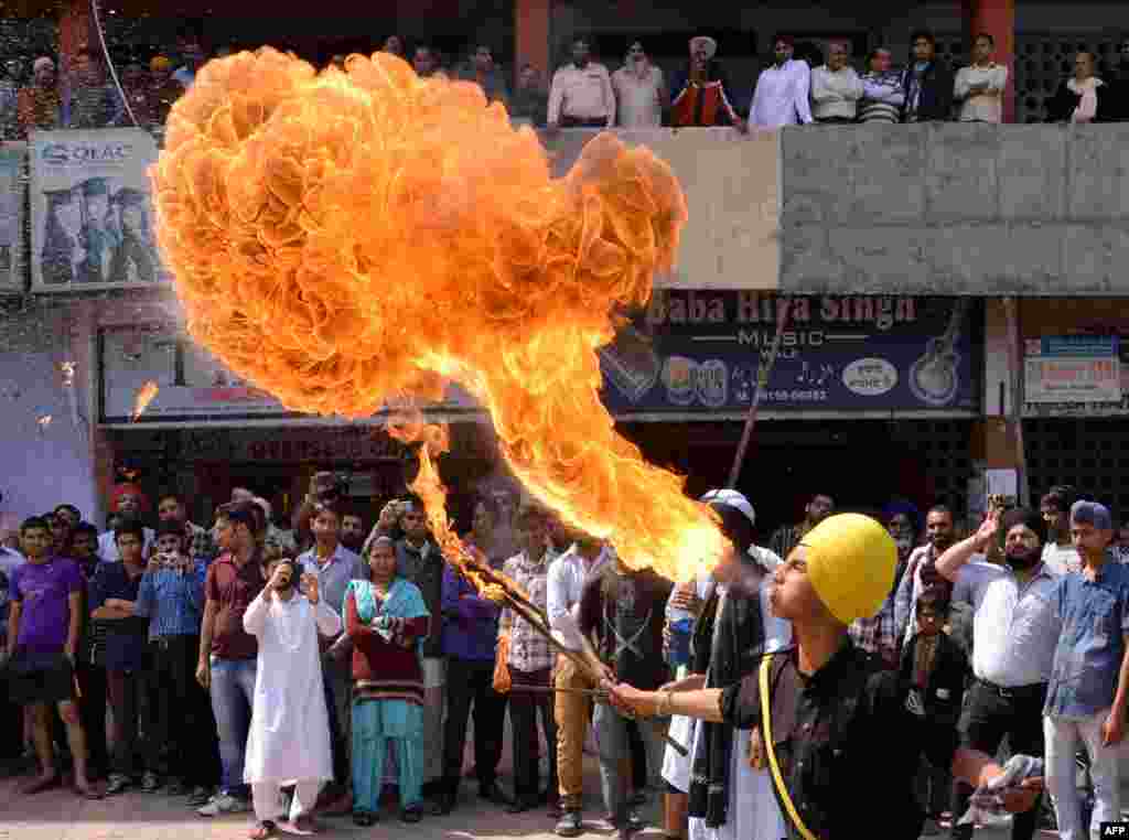 Seorang remaja Sikh India melakukan aksi dengan api saat memperagakan seni beladiri "Gatka" di kota Amritsar.