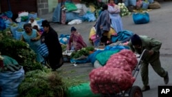 En esta fotografía del 8 de diciembre de 2018, un hombre empuja sacos de cebollas en un mercado callejero en La Paz, Bolivia. 