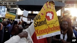 Mtu akishikilia bango linalosema "tunapiga vita chuki dhidi ya wahamiaji" wakati wa maandamano nchini Afrika Kusini