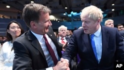 英国外相亨特祝贺约翰逊（右）当选英国首相。