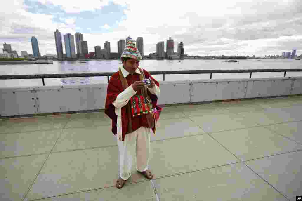 Tomas Mamani dari La Paz, Bolivia, melihat kameranya setelah mengambil foto di luar markas besar PBB di New York (22/9). (AP/Jason DeCrow) 
