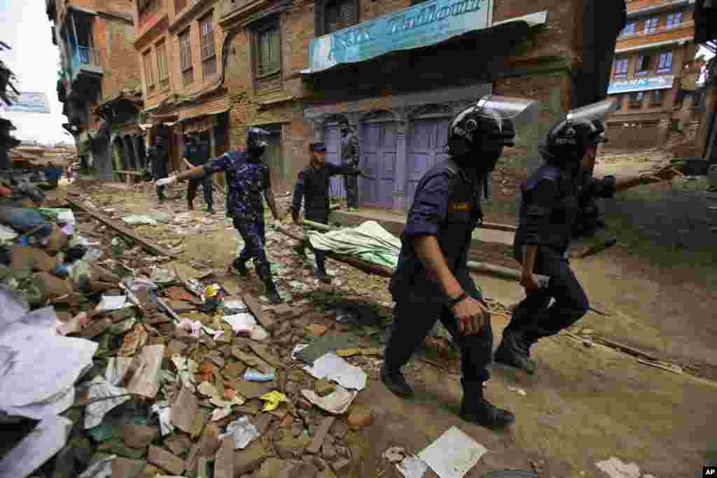 Nepalese rescue team carry the body of a victim recovered from a building that collapsed after an earthquake in Bhaktapur, near Kathmandu, Nepal.