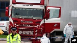 FILE - Police forensic officers attend the scene after a truck was found to contain a large number of dead bodies, in Grays, South England,Oct. 23, 2019.