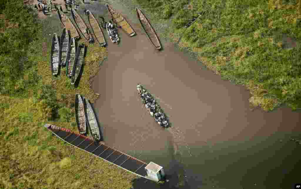 A pirogue packed with passengers arrives at a dock after crossing a waterway near the town of Malakal, seen from an airplane over South Sudan, Dec. 30, 2013.