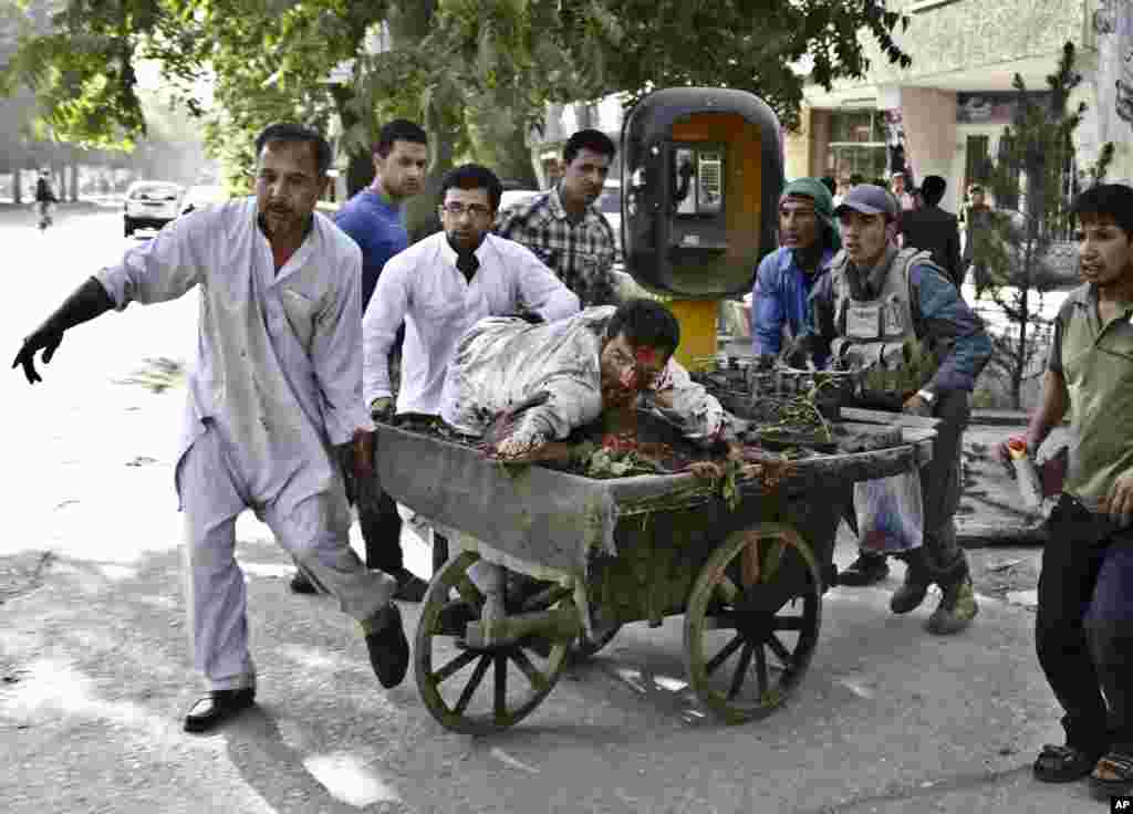 Afghans rush a wounded man to receive treatment after a suicide car bomber struck outside the Supreme Court in Kabul, Afghanistan. The suicide car bomber killed more than a dozen and wounded tens of people, police and health officials said.