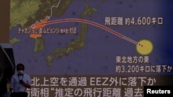 Orang-orang berjalan di depan layar yang menampilkan laporan berita tentang Korea Utara yang menembakkan rudal balistik ke Jepang, di Tokyo, Jepang, 4 Oktober 2022. (Foto: REUTERS/Issei Kato)