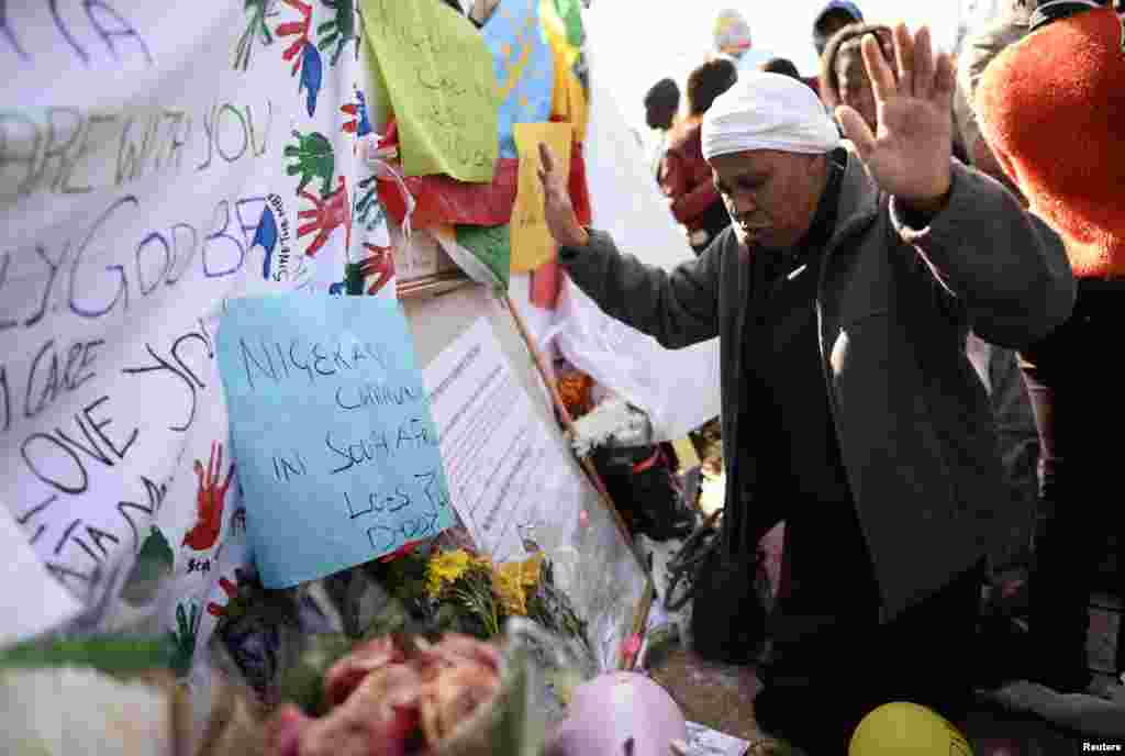 A well-wisher pays respect to ailing former South African President Nelson Mandela outside the Mediclinic Heart Hospital in Pretoria, June 27, 2013.