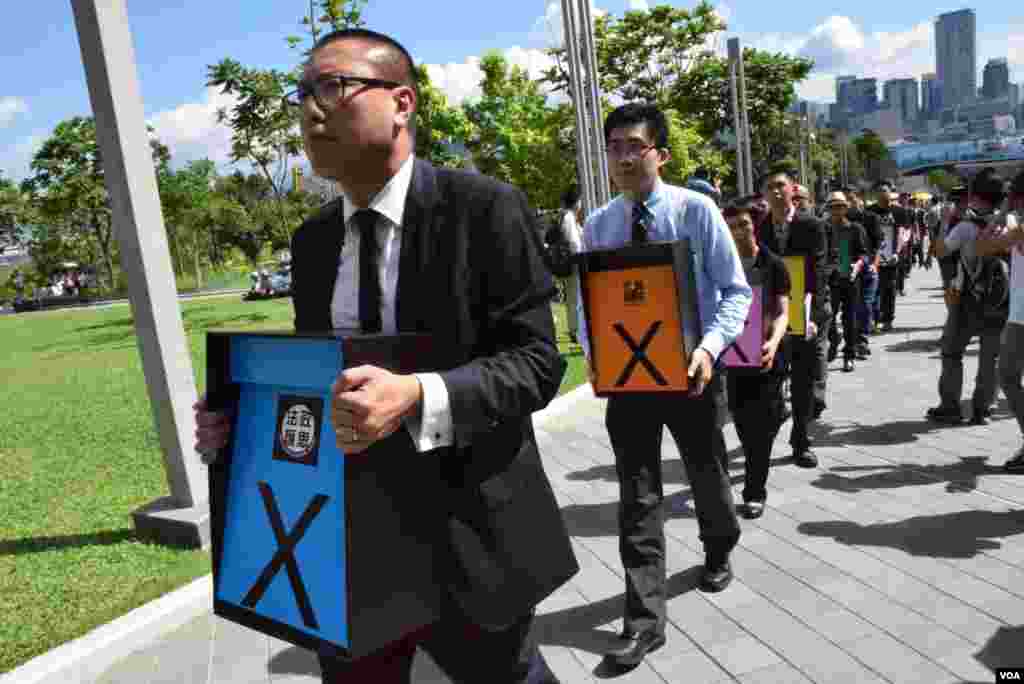 12個香港專業團體代表手持放入7,033封市民要求否決政改的「一人一信」的箱, 圍繞立法會一圈靜默遊行 (美國之音 湯惠芸攝)