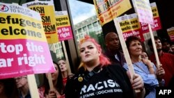 People hold anti-racism placards as they take part in a demonstration outside the headquarters of the Reform U.K. political party in London on Aug. 10, 2024.