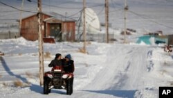 Residentes de Toksook Bay, Alaska, se movilizan en vehículos para todo terreno.