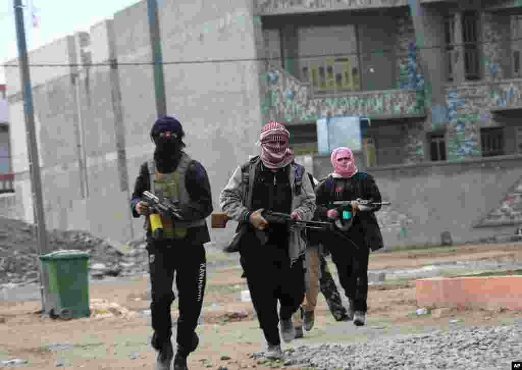 Gunmen patrol during clashes with Iraqi security forces in Fallujah, Jan. 5, 2014.