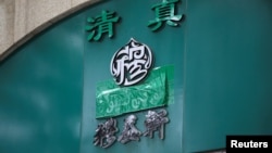 中國北京牛街一帶的一家清真餐館招牌上的阿拉伯字樣被遮蓋起來。 （2019年7月19日）