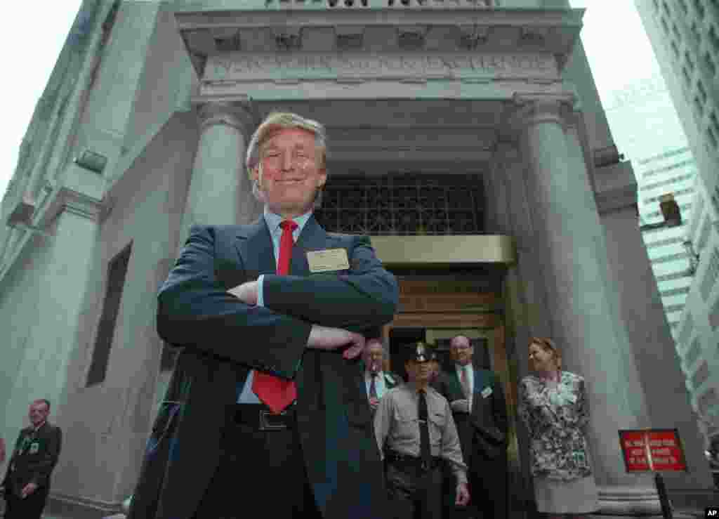 Donald Trump berpose di luar Bursa Efek New York setelah mendaftarkan saham-sahamnya, 7 Juni 1995. (AP/Kathy Willens)