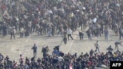 Pristalice egipatske vlade (dole) i demonstranti protiv nje (gore) sukobili su se danas na kairskom trgu Tahrir gađajući se međusobno kamenjem