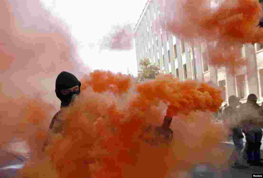 A protester holds a smoke flare during a rally against the law to provide separatist-held regions with a special status, near the Ukrainian parliament, in Kyiv, Sept. 17, 2014.