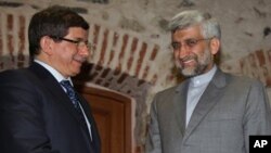 Turkey's Foreign Minister Ahmet Davutoglu (L) and Iran's Chief Nuclear Negotiator Saeed Jalili pose for cameras before their meeting on Iran's nuclear program, in Istanbul, Turkey, April 13, 2012.