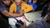 Para ajudan menutup wajah Ketua DPR Setya Novanto saat diangkut menuju Rumah Sakit Cipto Mangunkusumo di Jakarta, hari Jumat (17/11). 