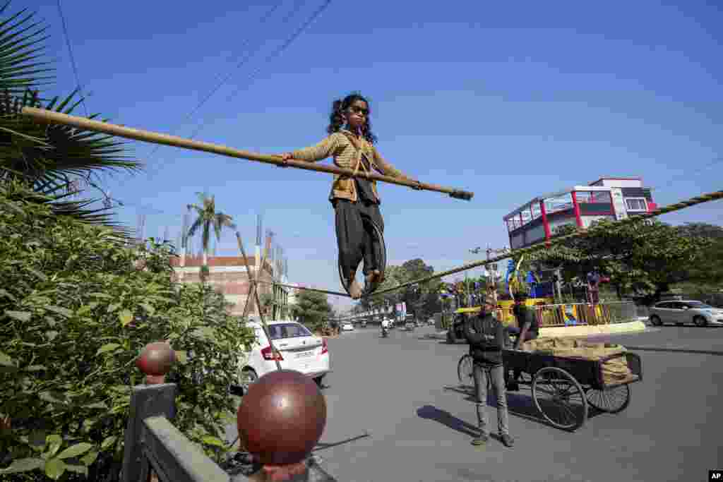 Maria, a six-year-old girl from Chhattisgarh state, displays her tight rope walking skills to attract alms from people at a roadside in Prayagraj, Uttar Pradesh, India.