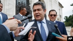 FILE - Honduran PHonduran President Juan Orlando Hernandez answers questions from the Associaresident Juan Orlando Hernandez answers questions from the Associated Press, Aug. 13, 2019, as he leaves a meeting at the Organization of American States, in Washington.