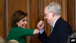 House Speaker Nancy Pelosi of Calif., left, and Senate Majority Leader Mitch McConnell of Ky., right, bump elbows as they attend a lunch with Irish Prime Minister Leo Varadkar on Capitol Hill in Washington, Thursday, March 12, 2020. (AP Photo/Susan Walsh)