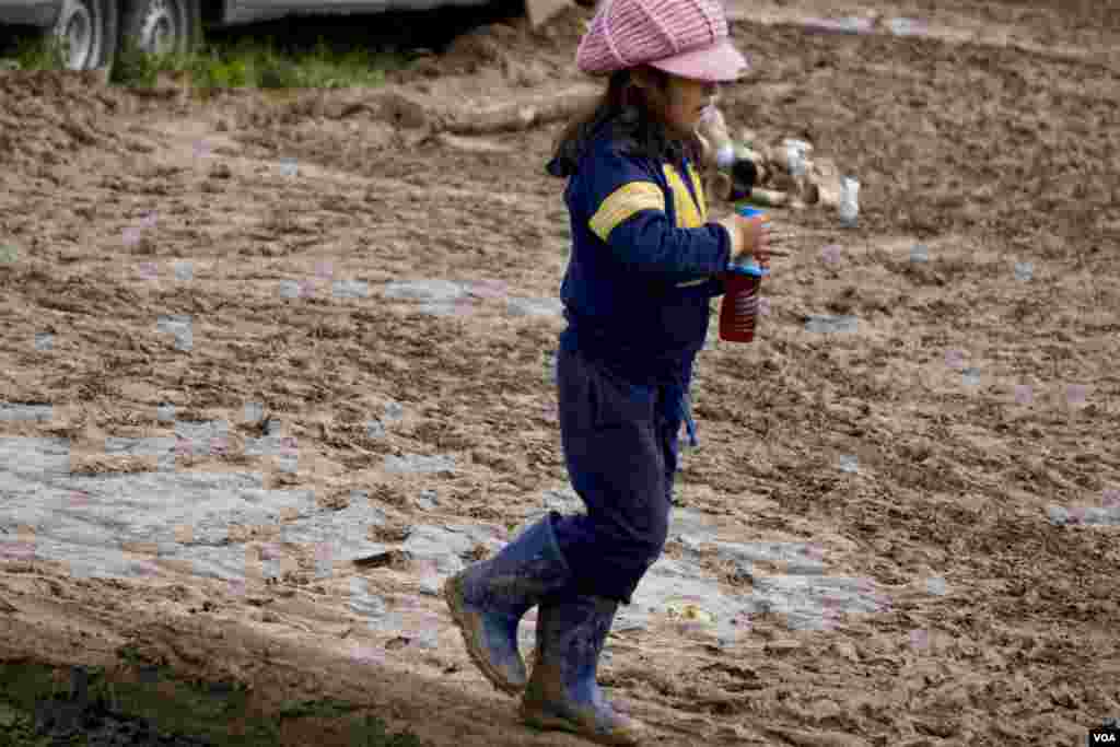 A Syrian girl navigates a muddy field. (Jamie Dettmer for VOA)