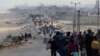 Sejumlah warga Palestina berusaha kembali ke rumah mereka di utara Gaza dengan berjalan melewati pos pemeriksaan Israel di wilayah Gaza tengah pada 15 April 2024. (Foto: Reuters/Ramadan Abed)