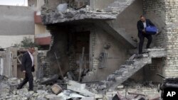 Orang-orang mengumpulkan harta benda mereka dari sebuah gedung yang rusak akibat ledakan bom mobil di Baghdad, Irak, 12 Januari 2016.