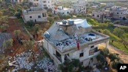 People inspect a destroyed house following a U.S. military operation in Atmeh, Syria, Feb. 3, 2022. Islamic State leader Amir Muhammad Sa'id Abdal-Rahman al-Mawla was killed in the raid.