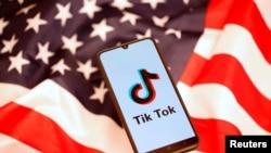 FILE PHOTO: TikTok logo is displayed on the smartphone while standing on the U.S. flag in this illustration