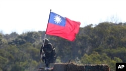 資料照：一名台灣士兵手舉台灣旗幟參加新竹舉行的軍演模擬反擊中國軍隊攻台。 （2021年1月19日）