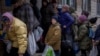 Sergei, 11, mengantre giliran untuk mendapatkan bantuan makanan yang didistribusikan di Bucha, pinggiran Kota Kyiv, Ukraina, pada 19 April 2022. (Foto: AP/Emilio Morenatti)
