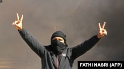 Un Tunisien brandit le signe "V pour victoire" lors d'une manifestation dans la ville de Tataouine, dans le sud du pays, le 12 février 2021.