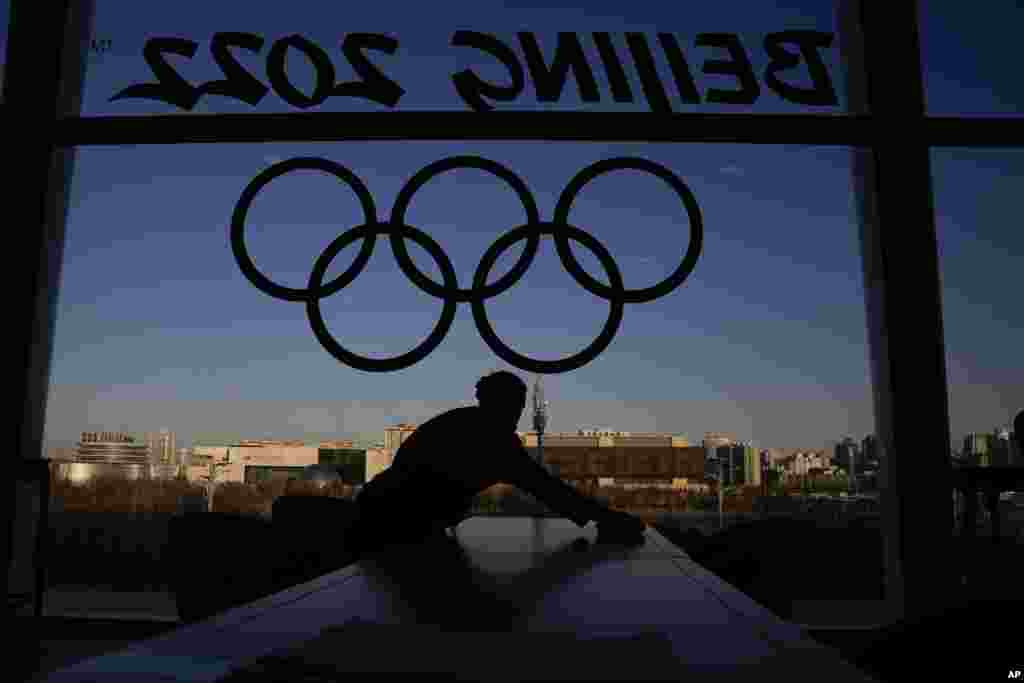 A woman cleans a table at the Olympics Main Media Center, Feb. 1, 2022, in Beijing.