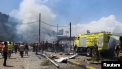 پلیس و آتش‌نشانان در محل انفجار خودروی بمبگذاری‌شده در عدن، یمن، یکشنبه ١٨ مهر ۱۴۰۰