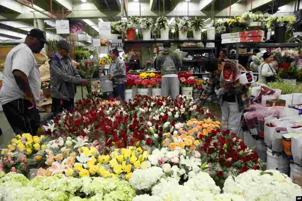 Buyers at the Flower Market look at Valentine's Day flowers for purchase in Los Angeles, California.