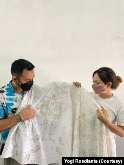 Yogi Rosdianta dan Santika pemilik Batik Mawar Putih, memamerkan batik pesanan pebasket NBA Justin Holiday. (Foto: Courtesy/Yogi Rosdianta)