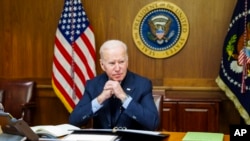 This image provided by The White House via Twitter shows President Joe Biden at Camp David, Md., Saturday, Feb. 12, 2022. Biden on Saturday again called on President Vladimir Putin to pull back more than 100,000 Russian troops massed near Ukraine’s border