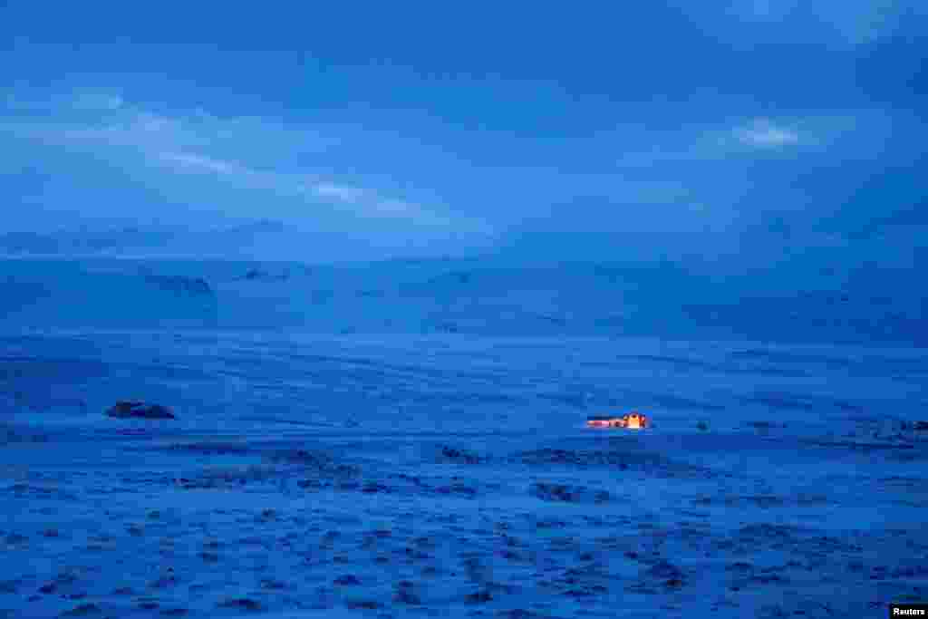 A house is pictured in the middle of a strong wind moving the snow in Myvatn, Iceland, Feb. 14, 2022.
