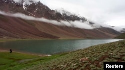 Tourists look at clouds hanging over Chandra Taal Lake in the Lahoul & Spiti district, in the northern Indian state of Himachal Pradesh, July 15, 2009. 